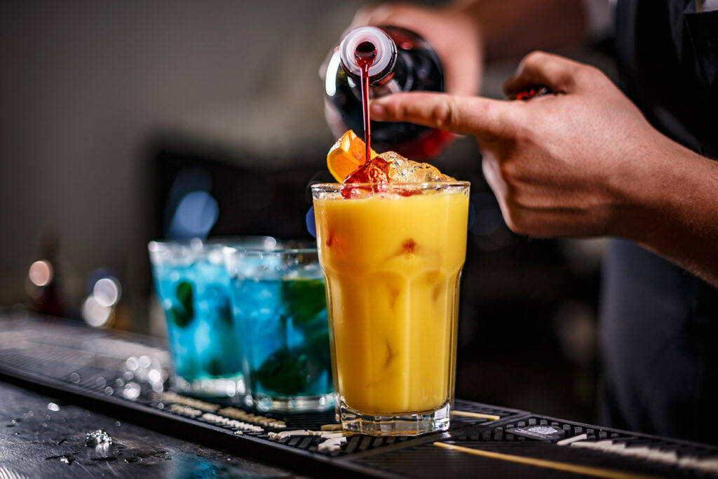 Bartender pouring a cocktail at the bar