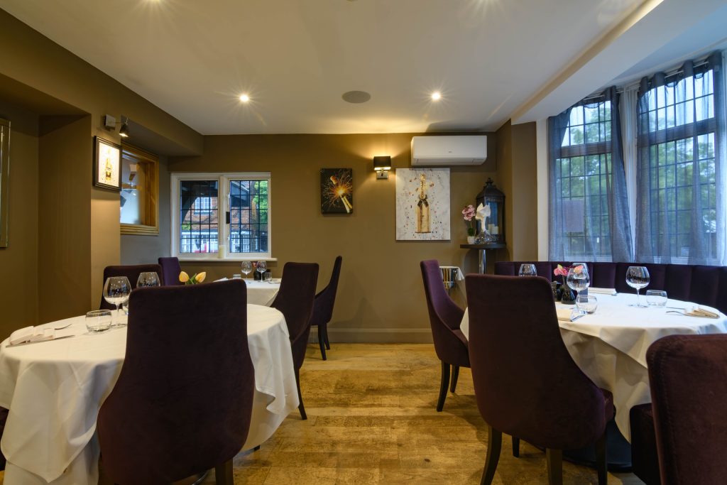 Dining room with round tables and leaded windows at The Gables