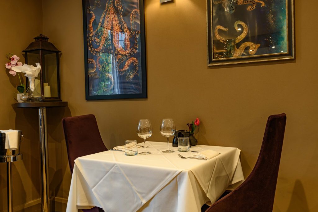Table for two beside artwork in a corner of the dining room at The Gables