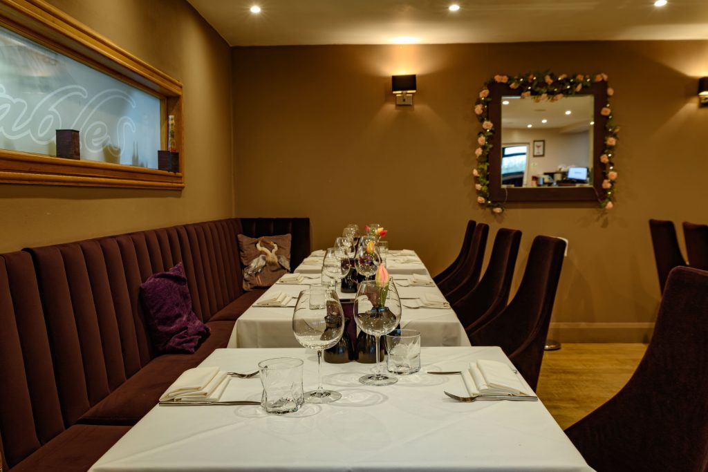 Banquette seating and long table laid for a party at The Gables