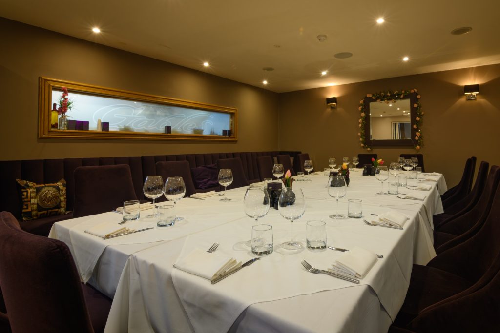 Long table set for a group in the dining room at The Gables