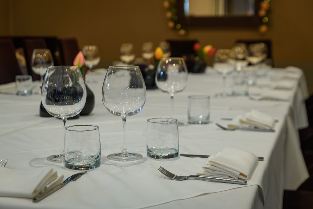 Table laid with wine glasses and white napkins for a group booking at The Gables