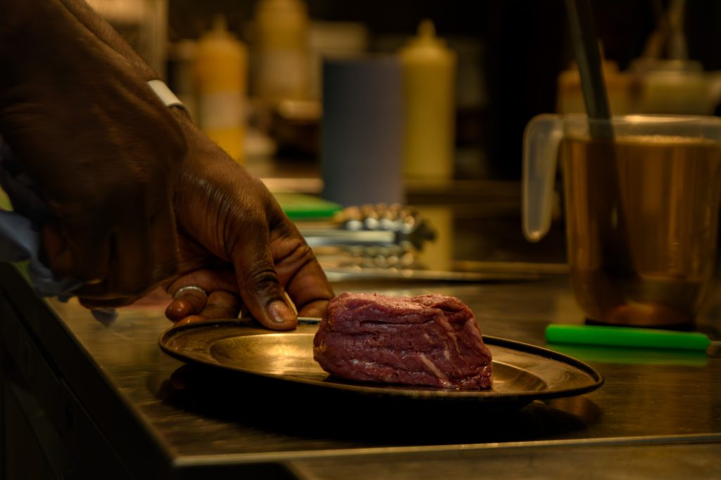 Chef preparing a fillet steak in the kitchen at The Gables