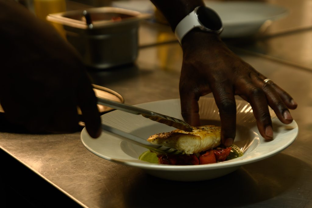 Chef plating a dish in the kitchen at The Gables