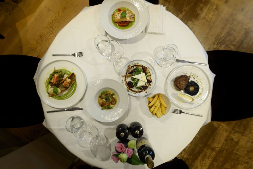 Overhead view of a round table with a selection of dishes and wine at The Gables